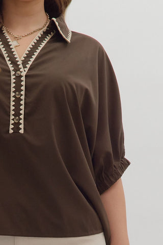 Brown blouse with decorative collar on a plain background