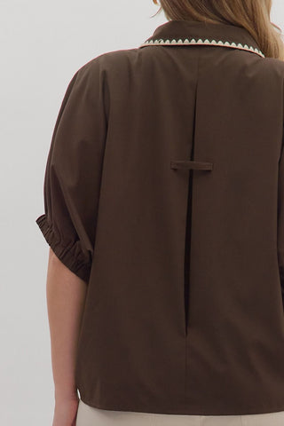 Brown jacket with a white collar on a plain background