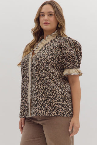 Woman wearing a leopard print blouse with ruffled sleeves on a white background