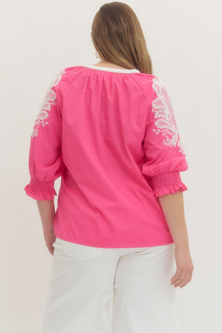 Pink blouse with white lace details on a white background