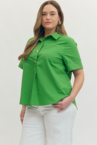 Woman wearing a green shirt and white pants on a plain background