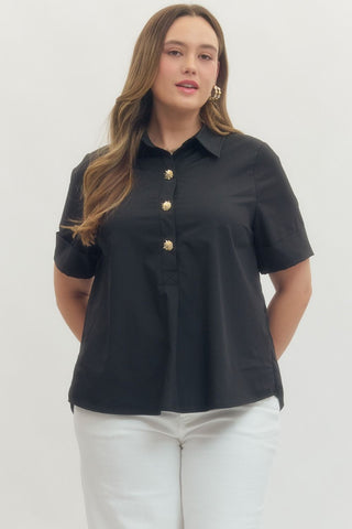 Woman wearing a black short-sleeve blouse with gold buttons on a white background