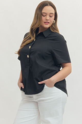 Woman wearing a black short-sleeve shirt with gold buttons on a white background