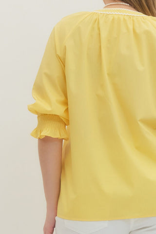 Yellow blouse with ruffled sleeves on a plain background