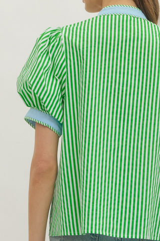 Green and white striped shirt worn by a person on a plain background