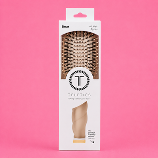 Hairbrush packaging with Teleties logo on a pink background