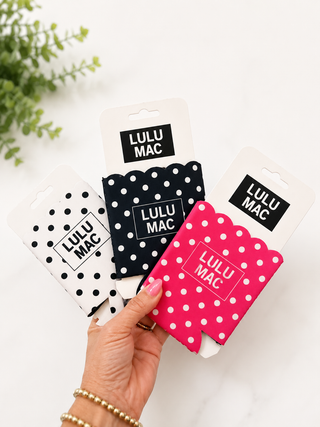 Hand holding Lulu Mac packaging on a white background with greenery