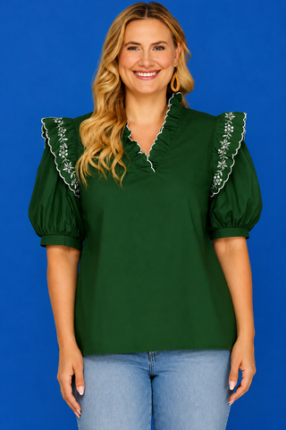 Green puff-sleeve blouse with light-wash jeans.
