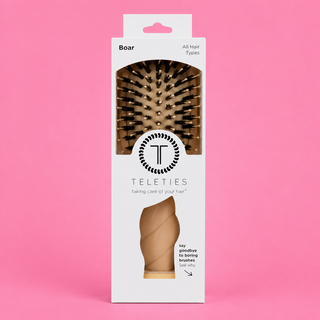 Teleties boar bristle brush packaging on a pink background