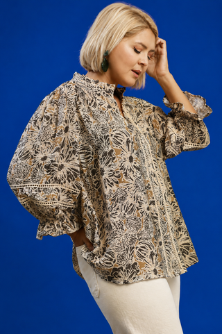 Woman wearing a patterned blouse against a blue background