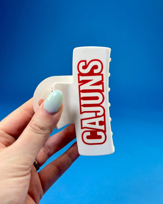 White oversized Cajuns claw hair clip with bold red lettering, durable spring hinge, and strong grip teeth for secure ever