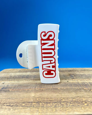 White oversized Cajuns claw hair clip with bold red lettering, durable spring hinge, and strong grip teeth for secure