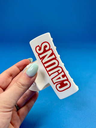 White oversized Cajuns claw hair clip with bold red lettering, durable spring hinge, and strong grip teeth for sec