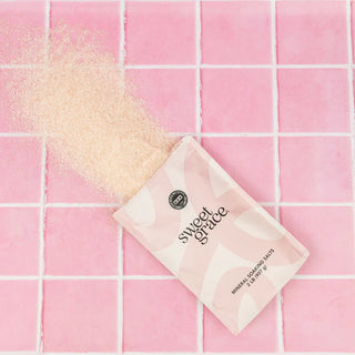 Sweet Grace mineral soaping salts packaging on a pink tiled background