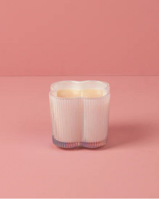 Candle in a decorative holder on a pink background
