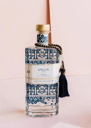 Decorative bottle with intricate blue patterns and a gold cap on a pink background