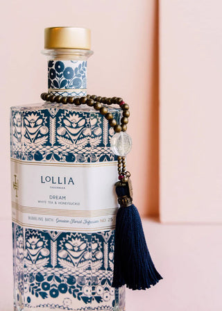 Lollia bottle with decorative elements on a pink background