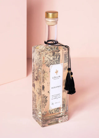 Decorative bottle with floral design and gold cap on a pink background