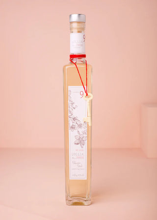 Bottle of alcohol with a label on a pink background