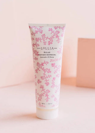 Lollia Relax shower gel tube with floral design on a light pink background