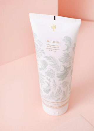 Tube of Creme de la Creme body wash on a pink background