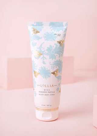 Lollia body product with floral design on a pink background