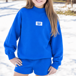 Youth Logo Lounge Top featuring a terrycloth interior, mock neckline, relaxed fit, and signature logo patch.