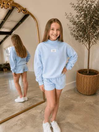 Youth Logo Lounge Top featuring a terrycloth interior, mock neckline, relaxed fit, and signature logo patch.