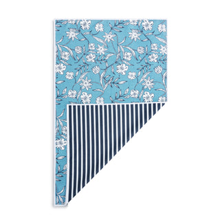 Floral patterned fabric with white flowers on a blue background, striped fabric with navy and white pattern, and white fabric.