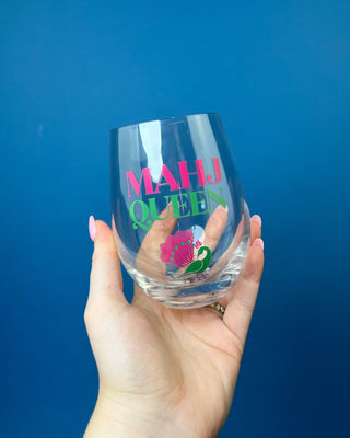 Mahj Queen stemless wine glass with vibrant pink and green lettering and a colorful peacock design on clear glass, perfect fo