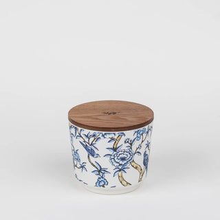 Ceramic jar with floral patterns and a wooden lid on a white background