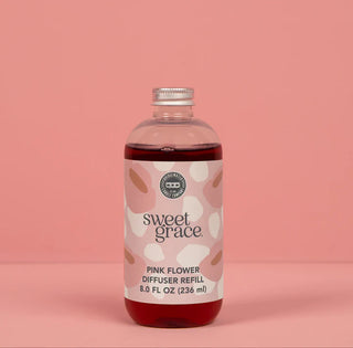 Bottle of Sweet Grace Pink Flower Diffuser Refill on a pink background