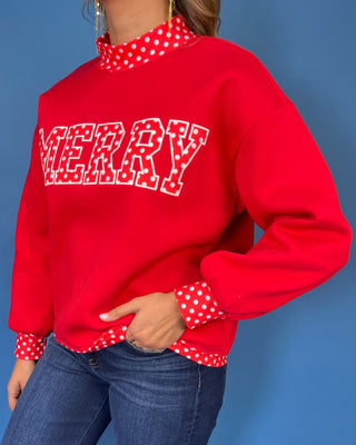 Red Merry graphic sweatshirt with white polka dot lettering, coordinating polka dot mock neckline, cuffs and he