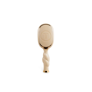 Gold and white hairbrush on a white background