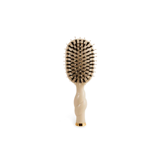 Beige hairbrush with black bristles on a white background