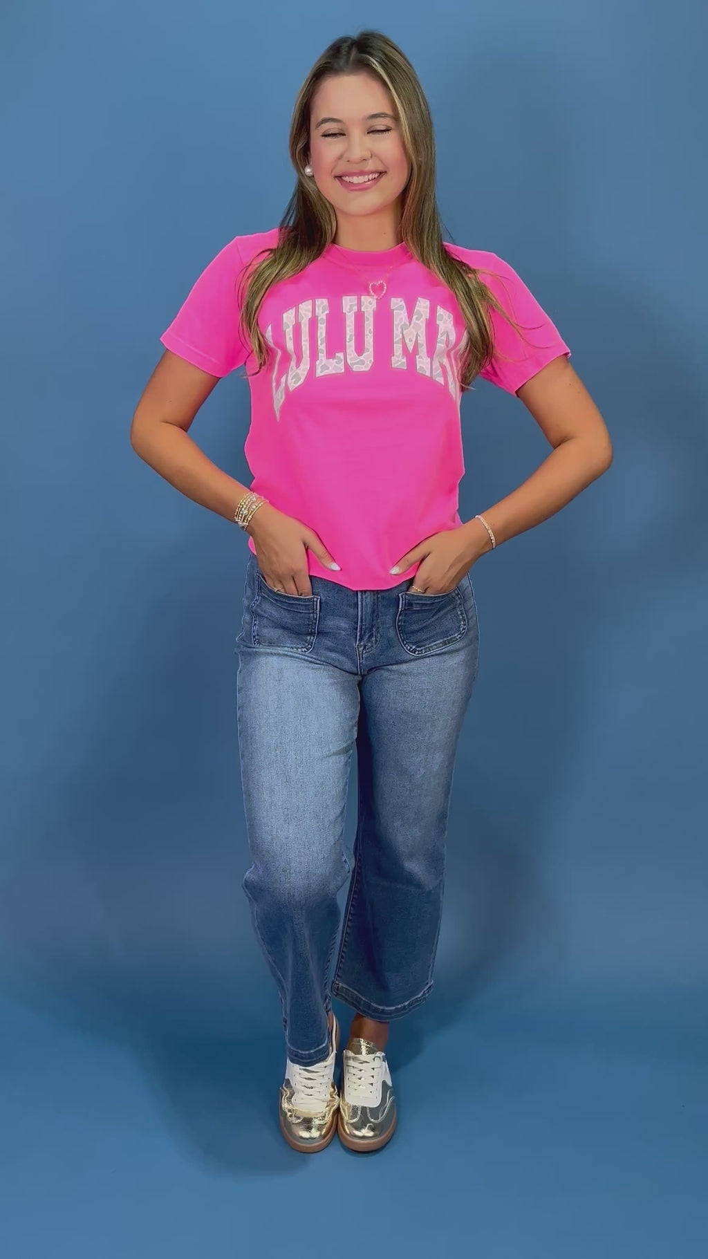 a bright pink short-sleeve t-shirt with 'LULU MAC' printed in white camo arched letters across the chest
