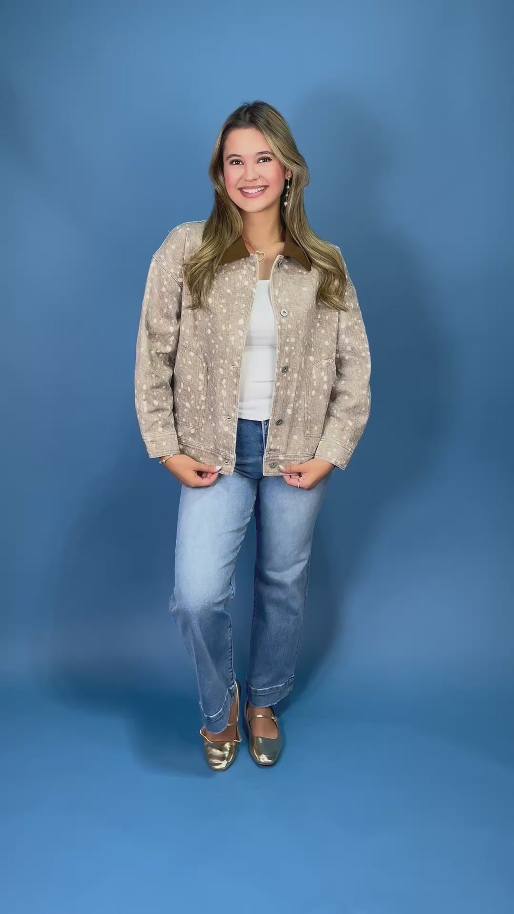  a beige long-sleeve button-up shirt with a white speckled pattern and a brown collar, paired with blue jeans