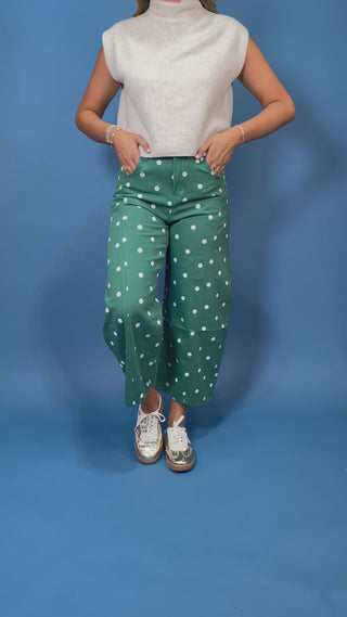 Green high-rise wide leg cropped jeans with an allover white polka dot print, front pockets, and seam detailing.