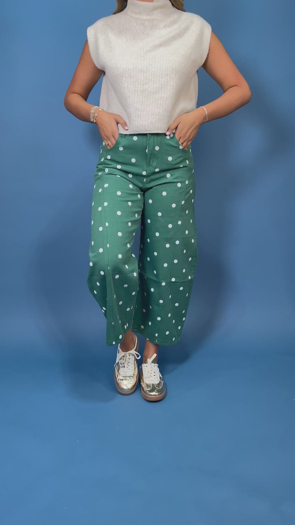 Green high-rise wide leg cropped jeans with an allover white polka dot print, front pockets, and seam detailing.