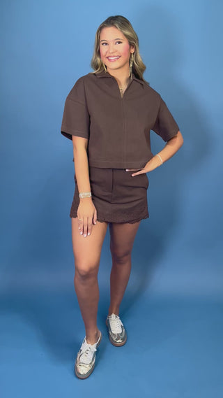Chocolate brown collared top with short sleeves, paired with a matching lace-trim mini skort.