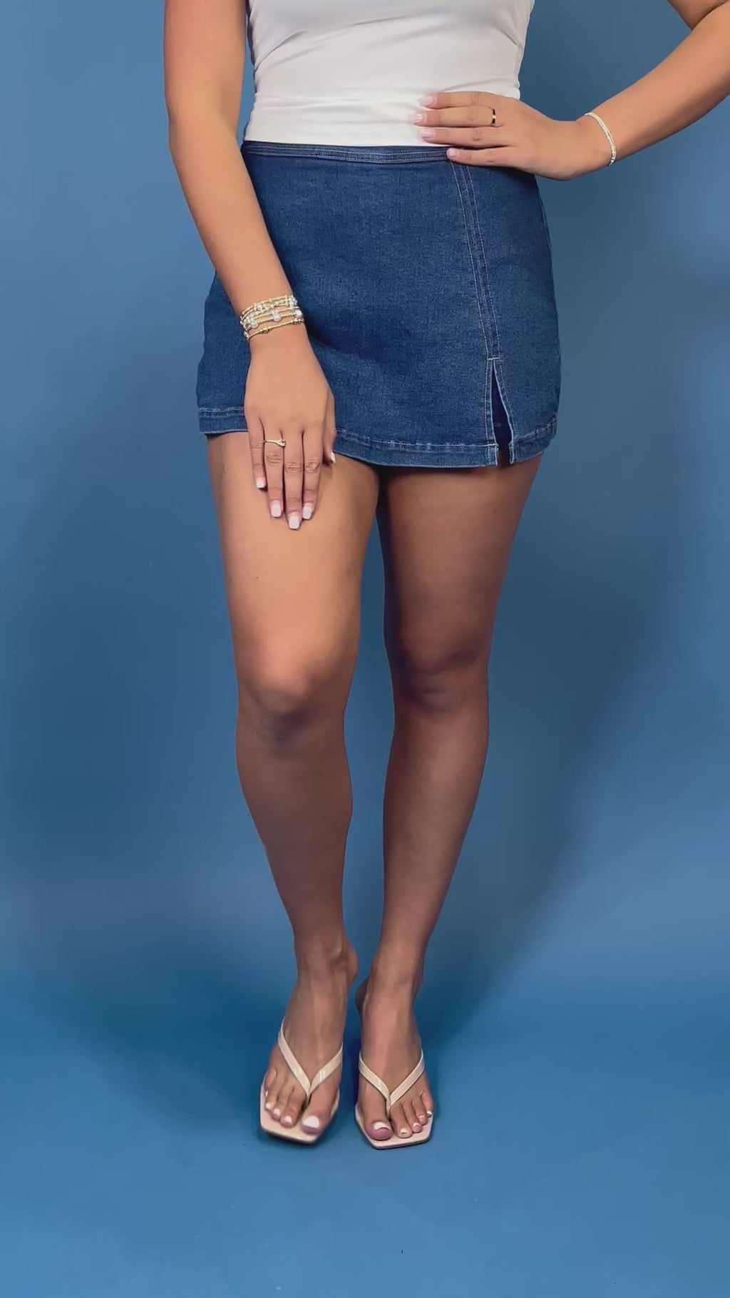 Dark wash denim skort with a flattering fitted silhouette, contrast stitching, and a chic front slit detail.