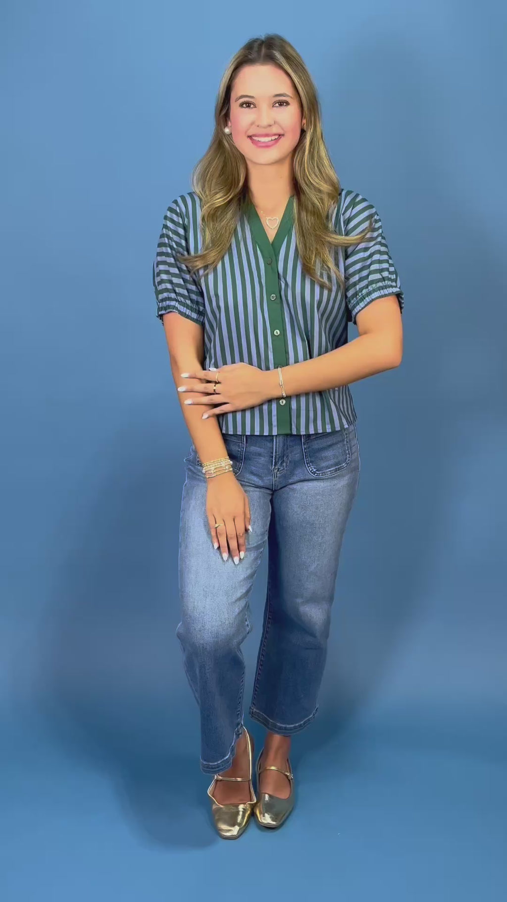 A woman modeling a short-sleeve button-up shirt with vertical navy and green stripes