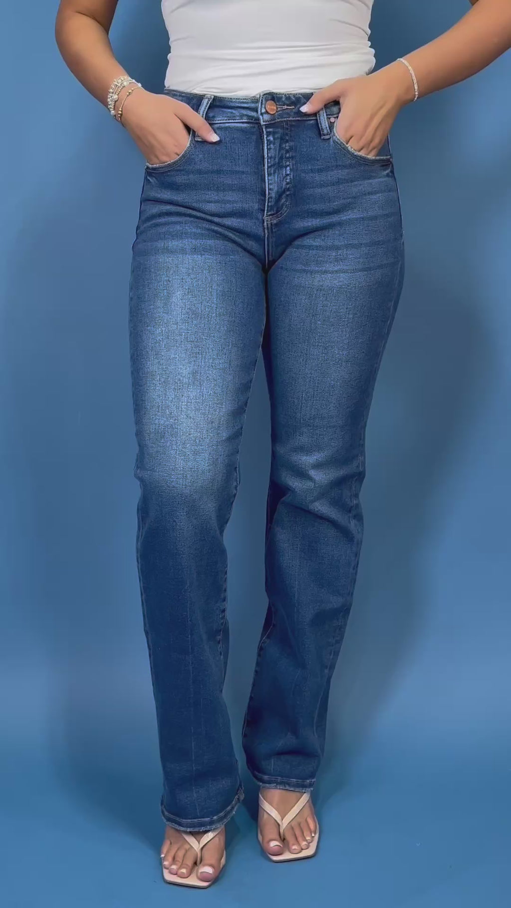 Medium-to-dark wash high-rise straight leg jeans with subtle fading, a clean finish, classic five-pocket styling, and a full-length silhouette.