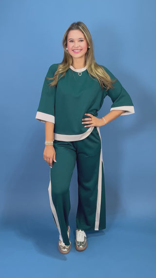 two-piece tracksuit with white contrast trim, featuring a short-sleeve top and matching wide-leg pants,
