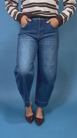 Dark wash high rise wide leg crop jeans with subtle fading and seamed cuff hem detail.