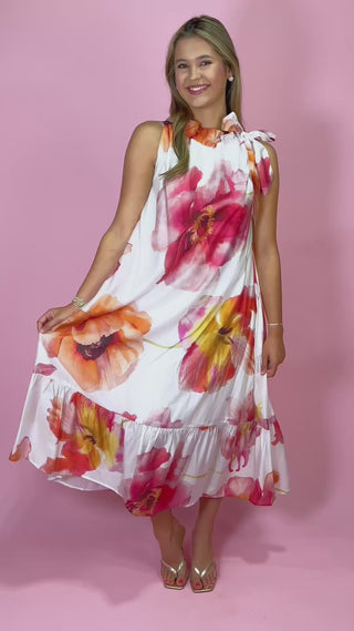 Woman wearing a floral top with a pink background