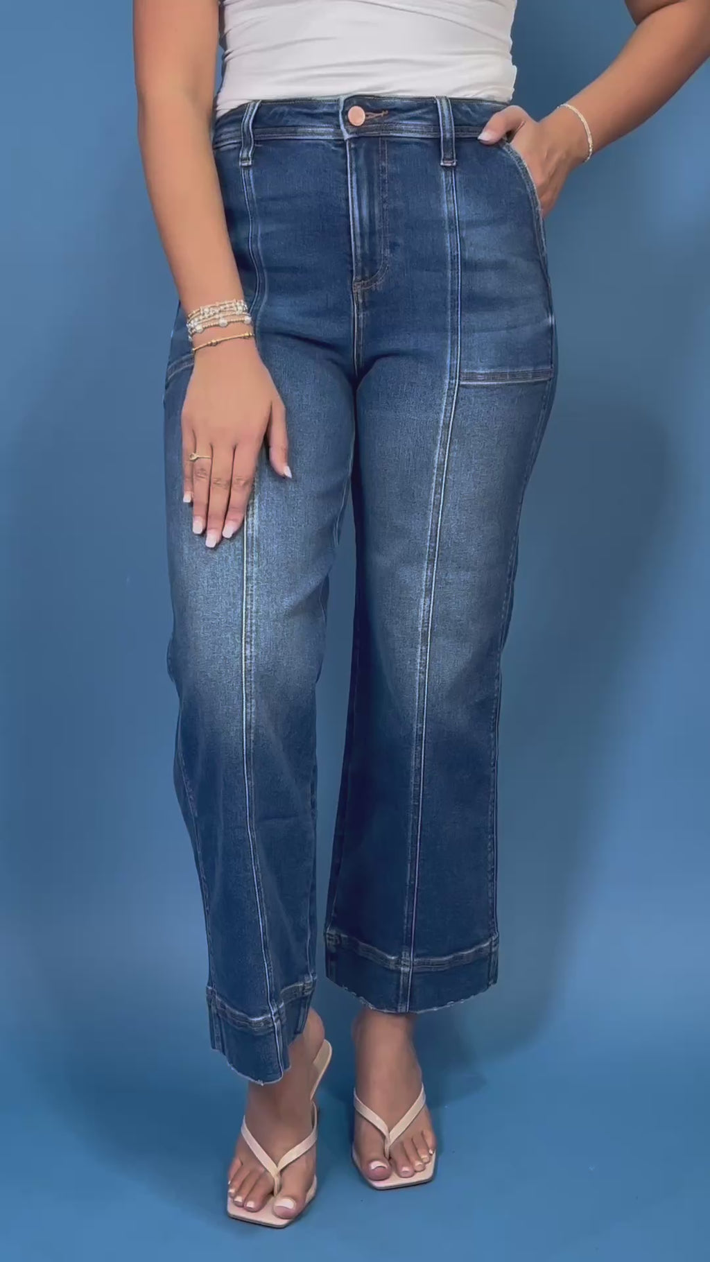 Dark wash high-rise cropped wide leg jeans with contrast front seam detailing, subtle fading, utility-inspired front pockets, and a wide cuffed hem.