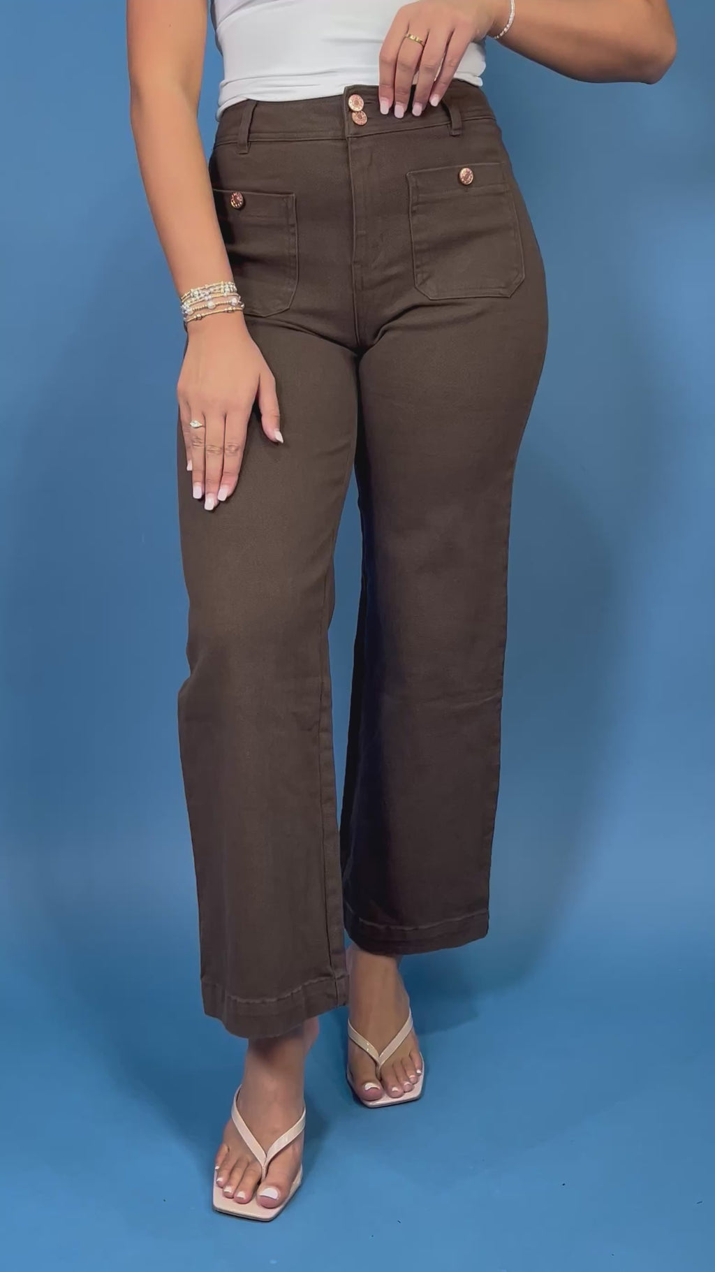 Chocolate brown high-rise wide leg pants with gold button details, front patch pockets, and a flattering cropped silhouette.