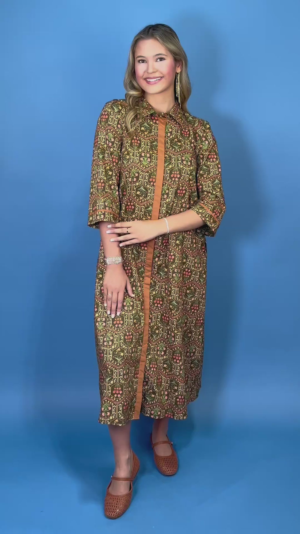 Olive floral print midi dress with contrast trim, three-quarter sleeves, button-front detail, and side pockets.