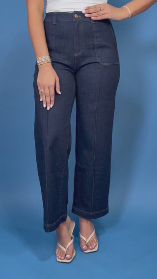 Dark wash high-rise wide leg jeans with front patch pockets, flattering seam details, and a cropped ankle-length silhouette.